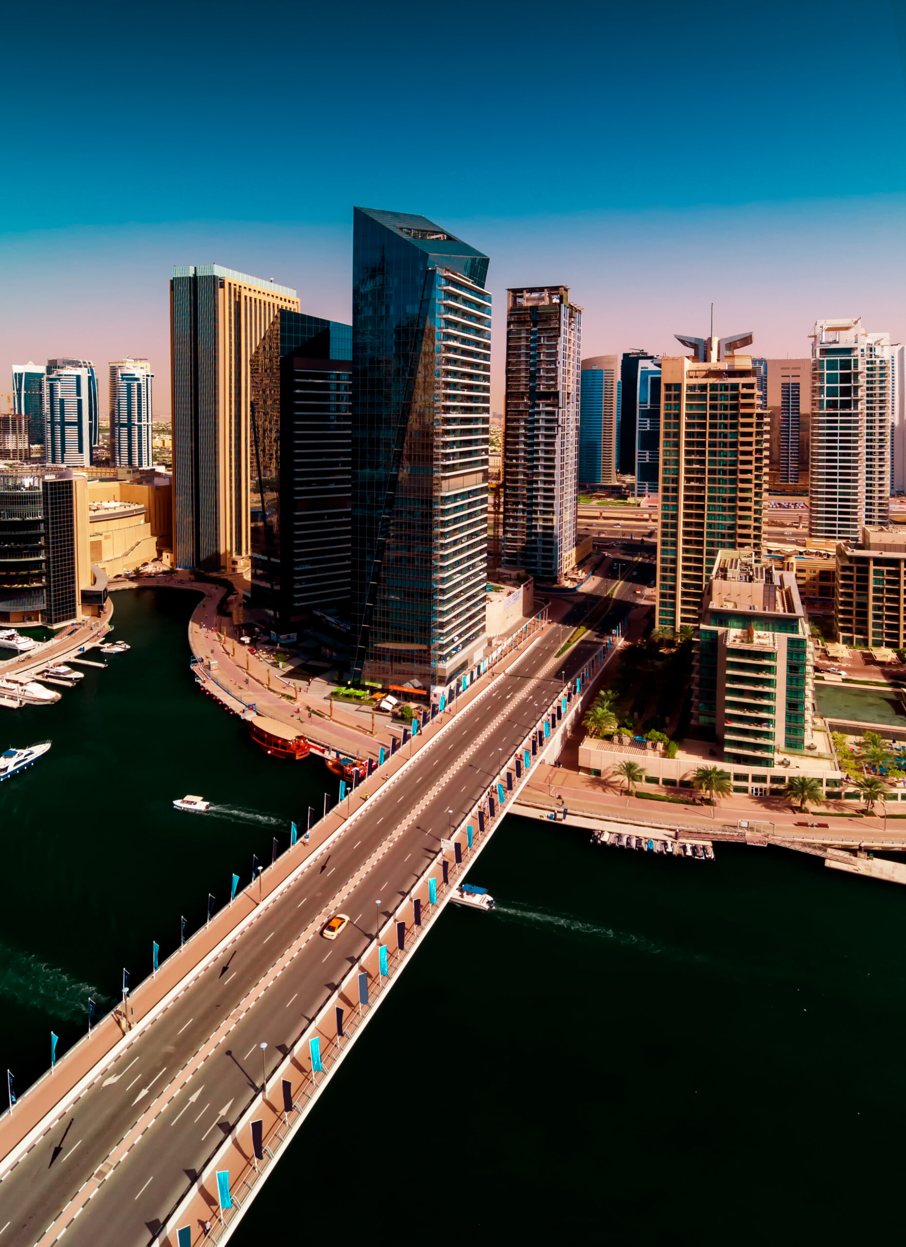 Amazing colorful dubai marina skyline with water canal and expensive yachts during sunny day, Dubai, United Arab Emirates.