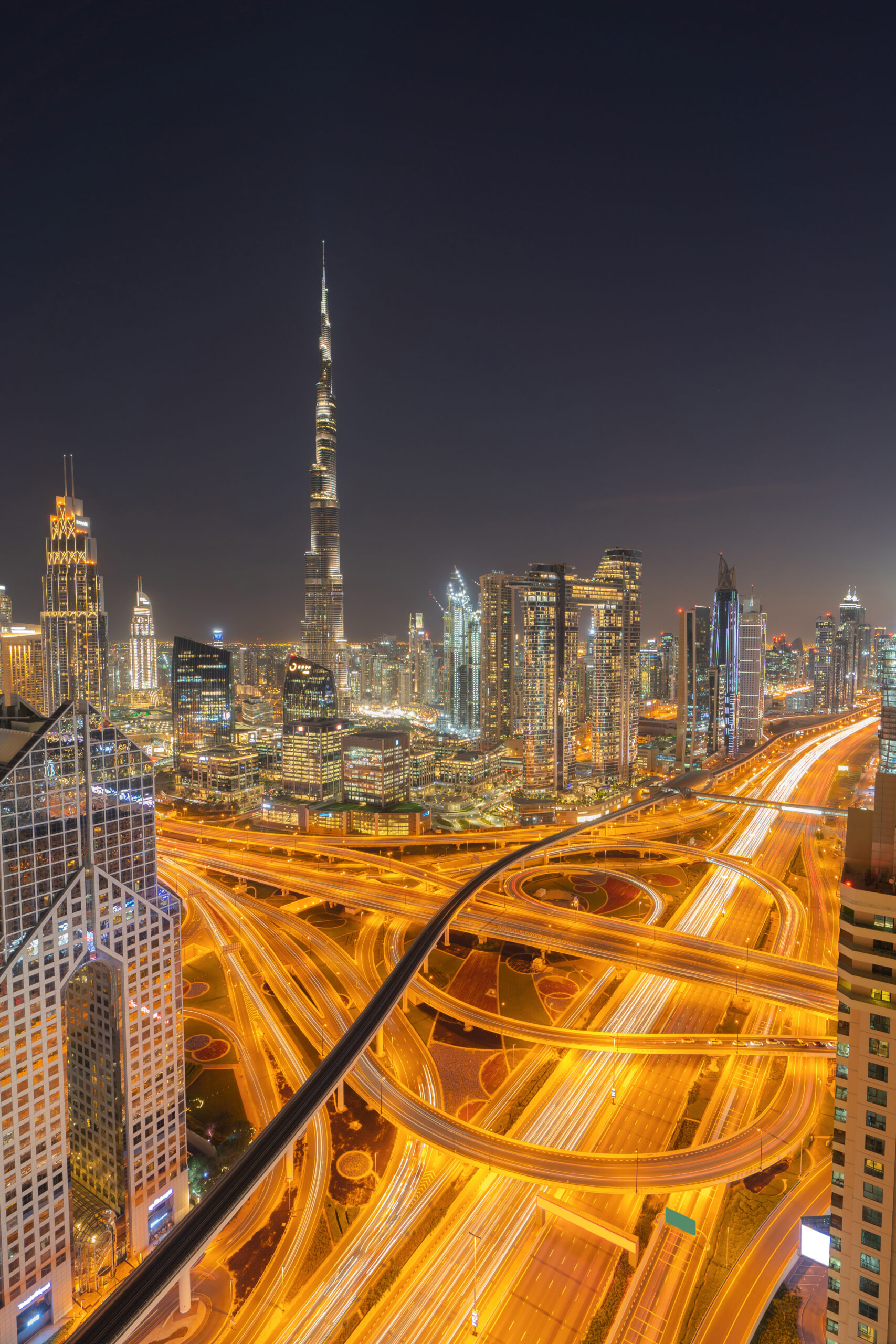 Aerial view of Dubai Downtown skyline, highway roads or street in United Arab Emirates or UAE. Financial district and business area in smart urban city. Skyscraper and high-rise buildings at night.